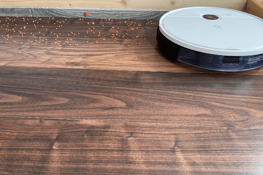 Yeedi Vac Hybrid reinigt Linsen auf einem Laminatboden